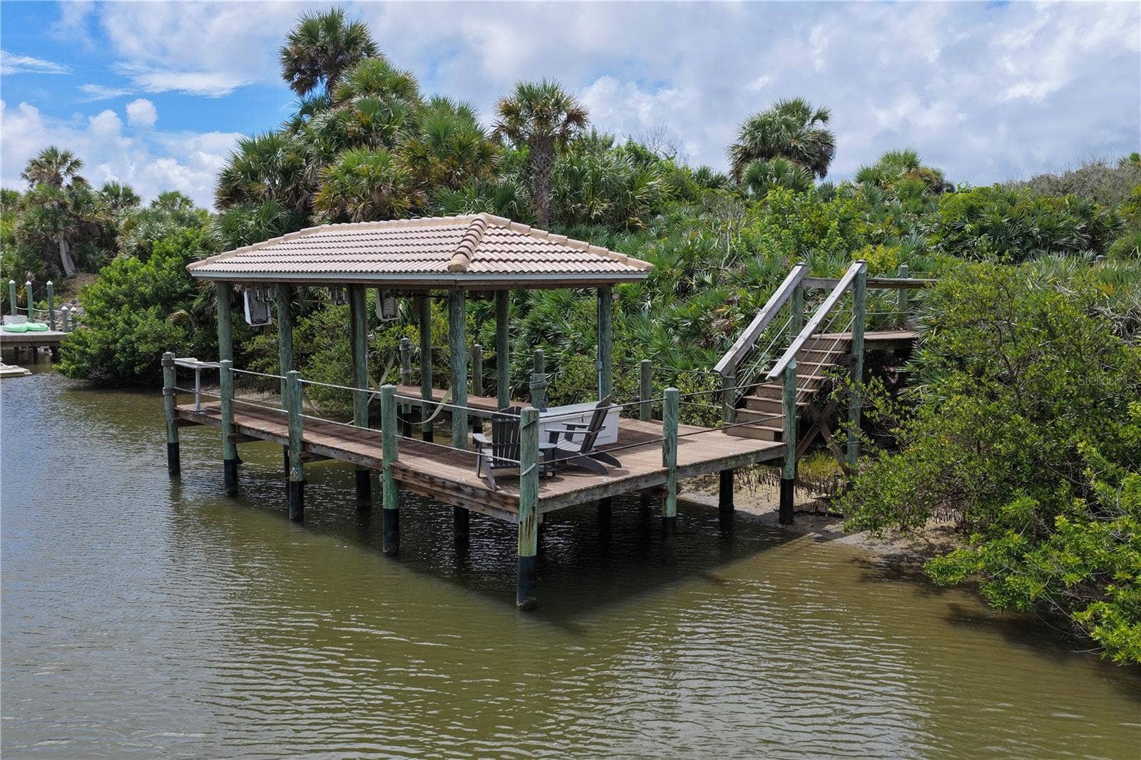 Tucked at the end of a private garden path, the covered dock becomes your gateway to the water, complete with electric and a 10,000-lb boat liftready when the Intracoastal is calling.