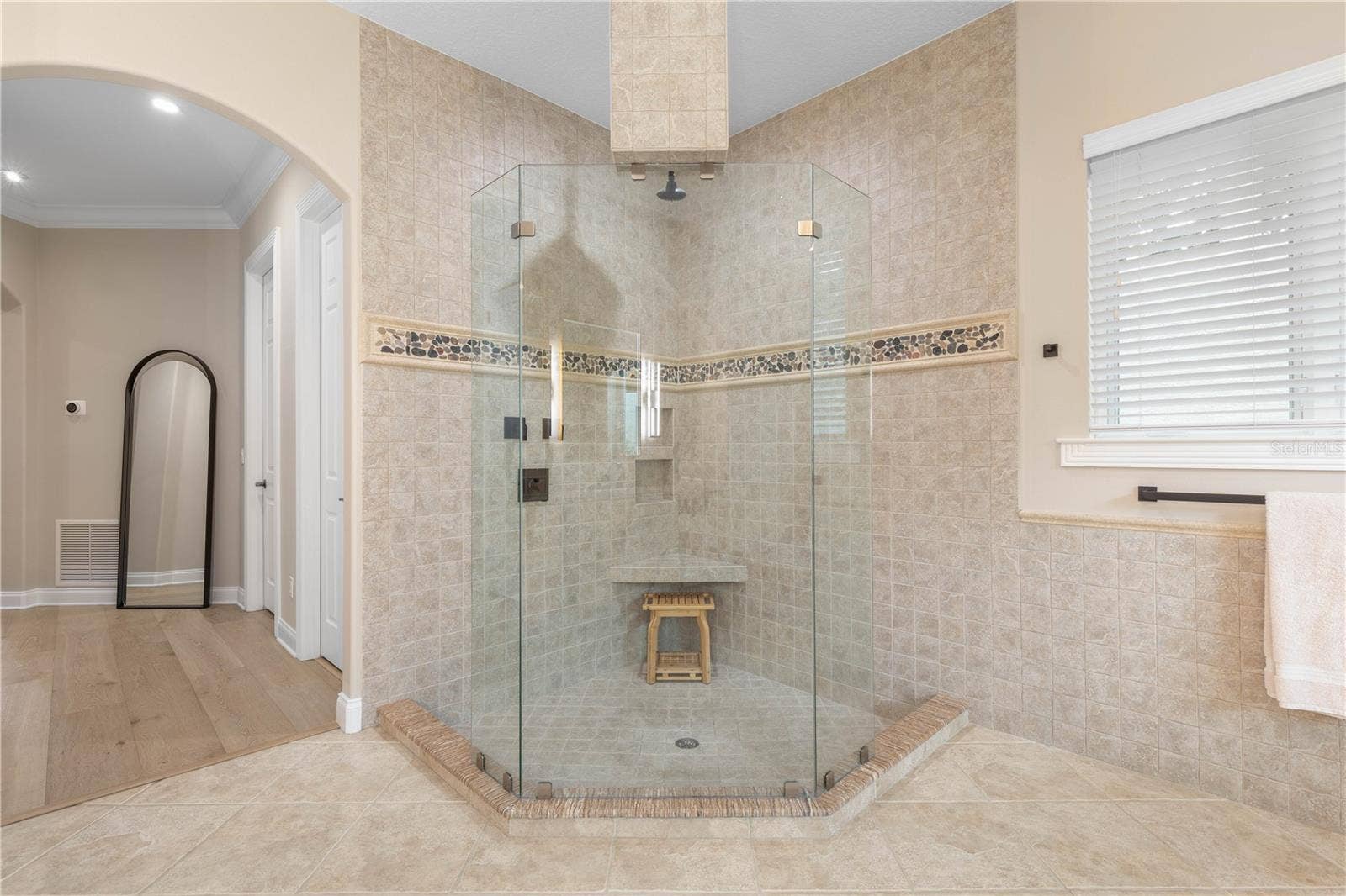 A walk-in shower that gives you room to move, with frameless glass, built-in seating and a clean, open design that keeps the primary bath feeling spacious