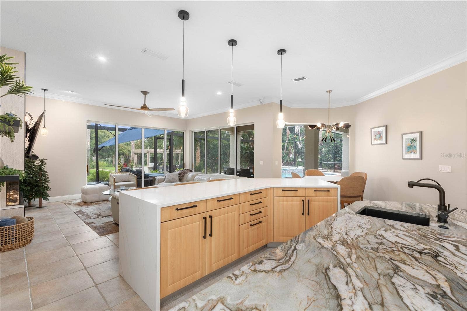 From meal prep to movie night, this open arrangement keeps the day connected, with generous counter space and a clear sightline from the kitchen to the family room and pool beyond.
