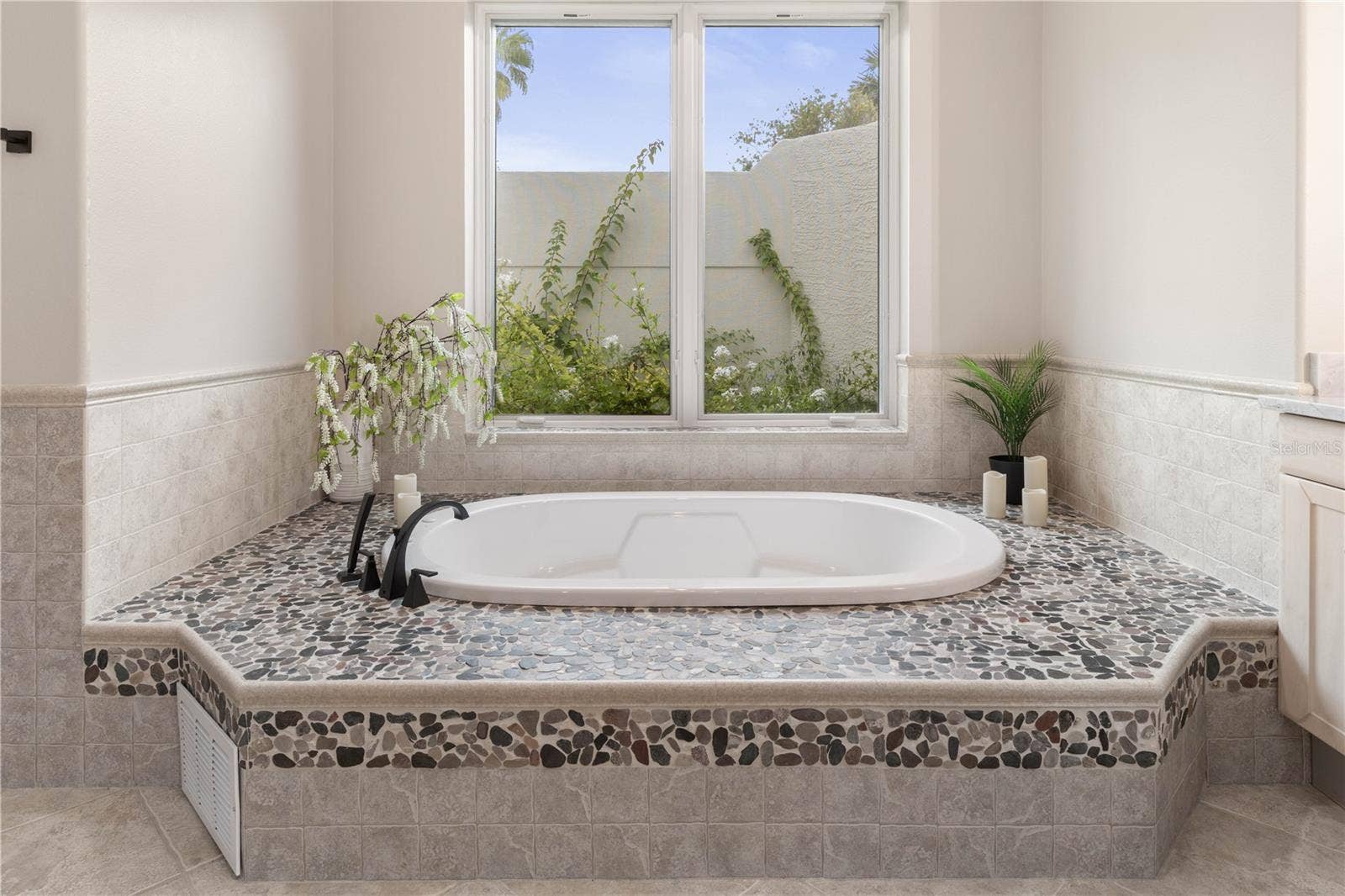 The kind of tub that makes you want to stay awhilebeautiful pebble-stone detailing turns an everyday soak into something a little more indulgent.