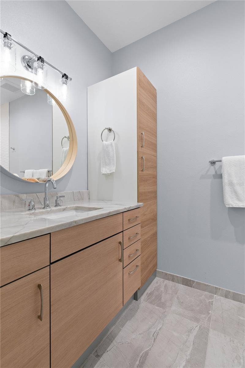 The ensuite bath continues the suites fresh, polished feel with sleek cabinetry, generous storage and a crisp contemporary finish.