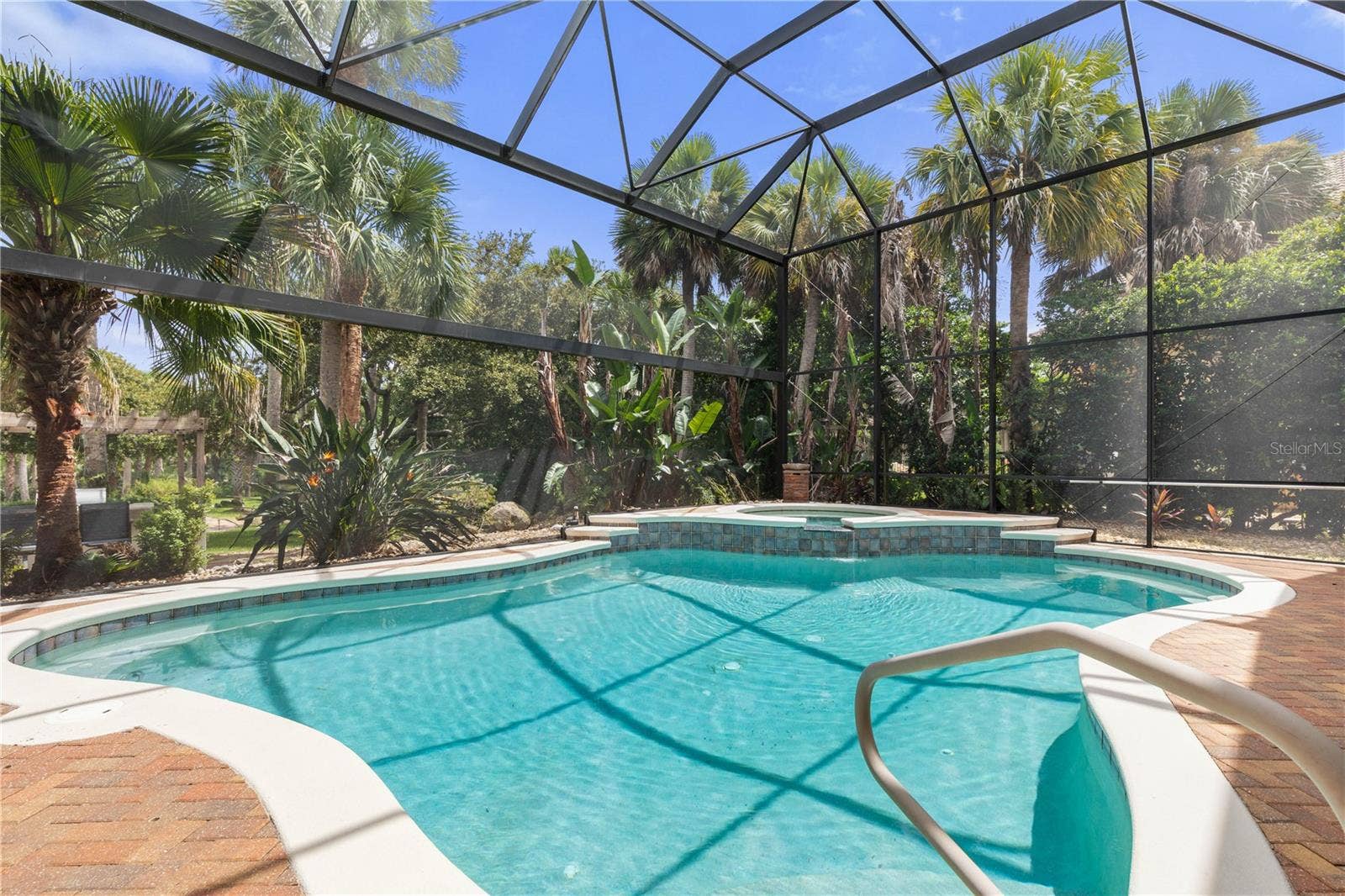 A sparkling pool, elevated spa, and a canopy of blue overhead set the scene for carefree days that feel like a permanent vacation.