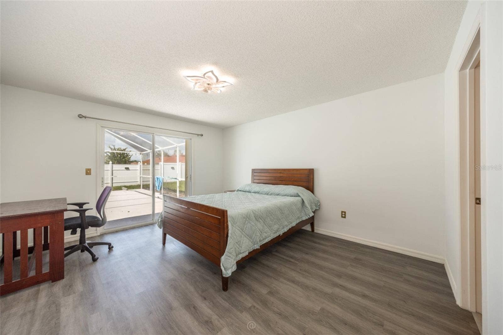 large primary suite with sliders to pool