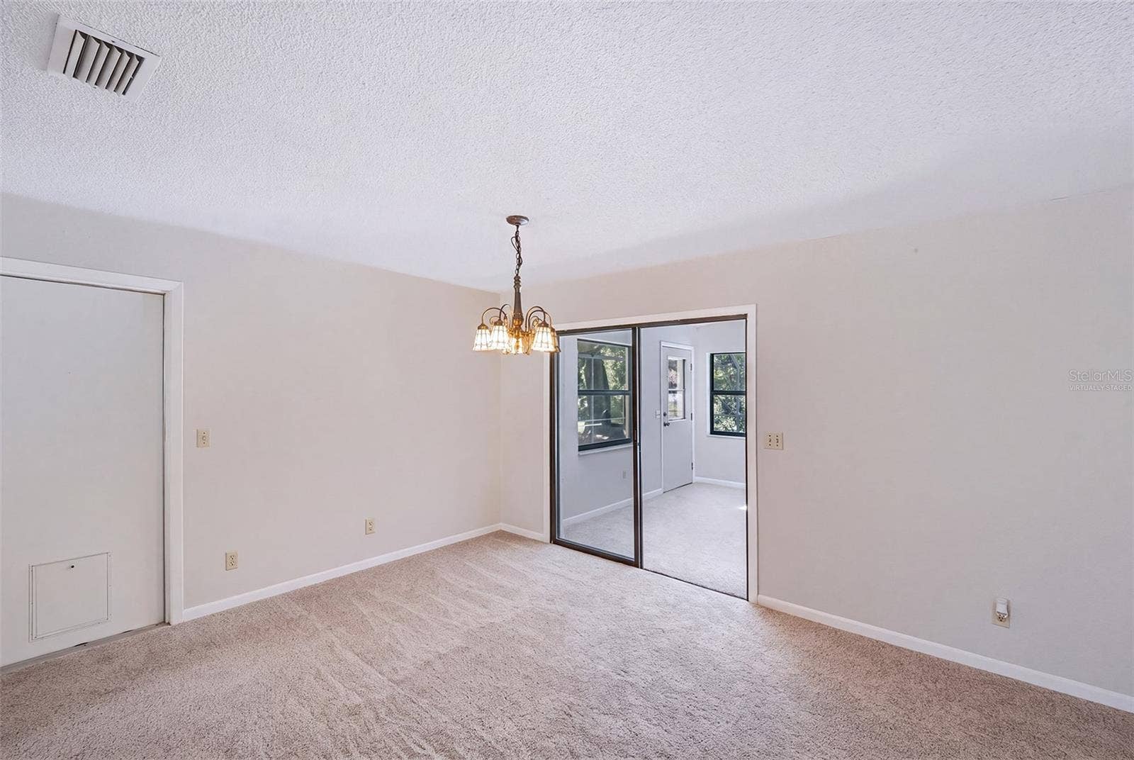 83 FARRAGUT DRIVE, Palm Coast, FL 32137 Virtually staged empty dinette adjacent to Florida room