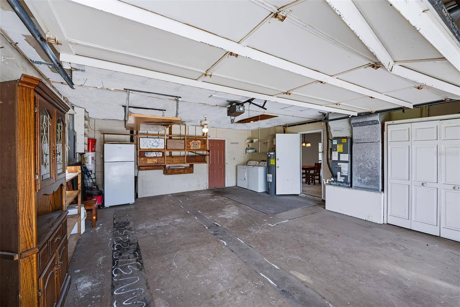 83 FARRAGUT DRIVE, Palm Coast, FL 32137 This 2-car garage exhibits plenty of storage space. This area also houses the HVAC, hot water heater and washer/dryer hook-up. Door to the right is an entry into the house, door at the back takes you out to the pool/lanai area