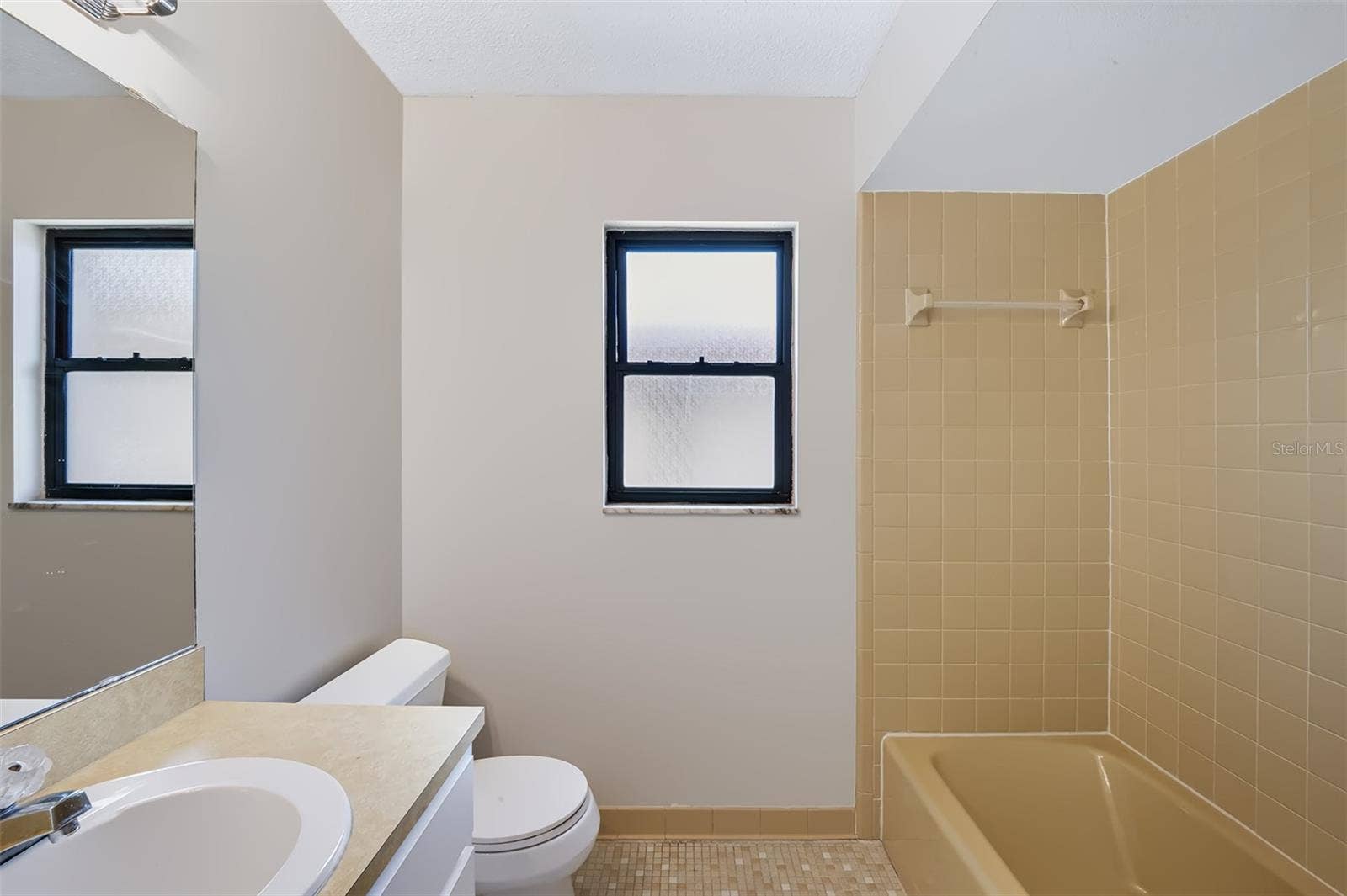 83 FARRAGUT DRIVE, Palm Coast, FL 32137 Secondary bathroom conveniently located in hall between both bedrooms. This bathroom also features retro-style glazed ceramic tile, it has a linen closet to the left of the sink with built-in medicine cabinet on wall, and has a tub/shower combination
