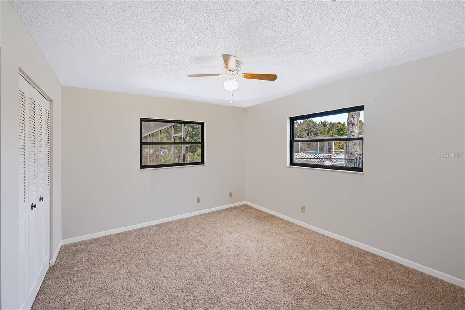 83 FARRAGUT DRIVE, Palm Coast, FL 32137 Secondary bedroom with double walk-in closets and view overlooking the pool/canal area