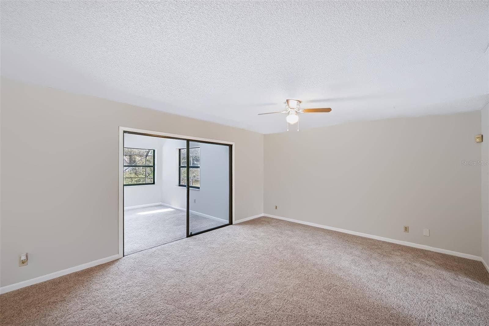 83 FARRAGUT DRIVE, Palm Coast, FL 32137 Living room with access to Florida room beyond the glass sliding doors