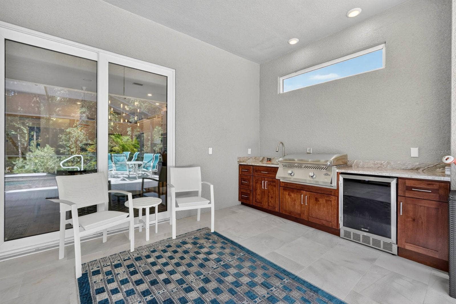 36 NEW WATER OAK DRIVE, Palm Coast, FL 32137 Outdoor kitchen features beautiful soft close cabinetry, granite counters and outdoor fridge and grill plus sink