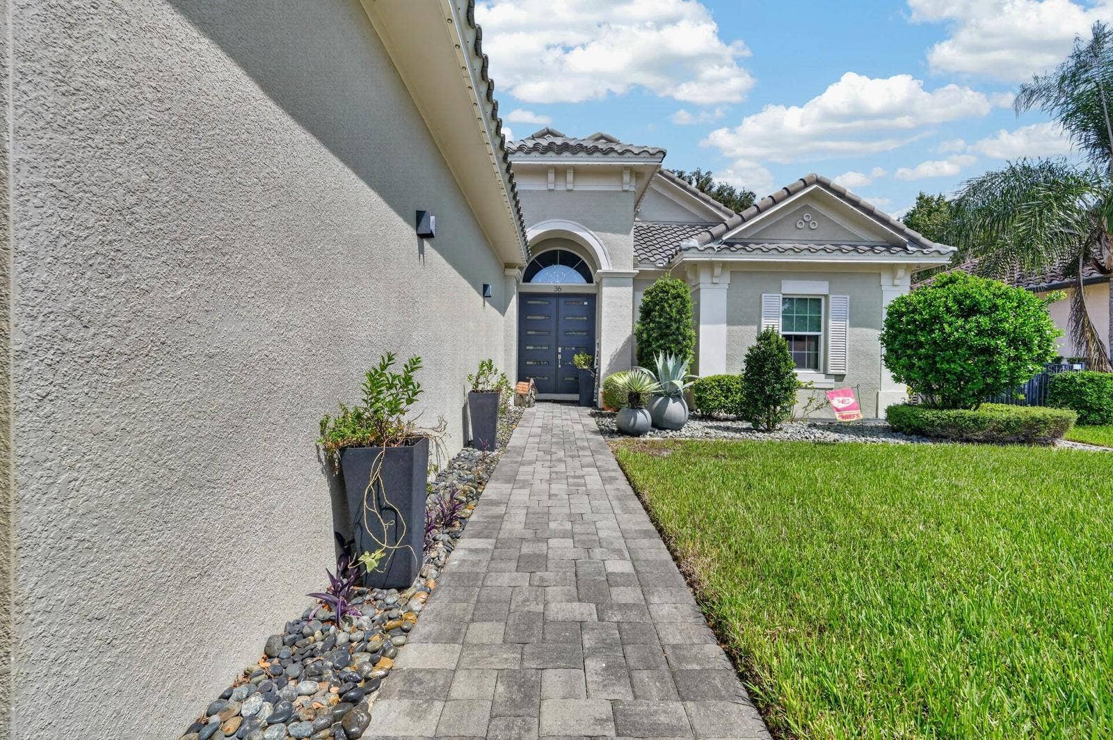 36 NEW WATER OAK DRIVE, Palm Coast, FL 32137 long paver sidewalk up to beautiful double door entry