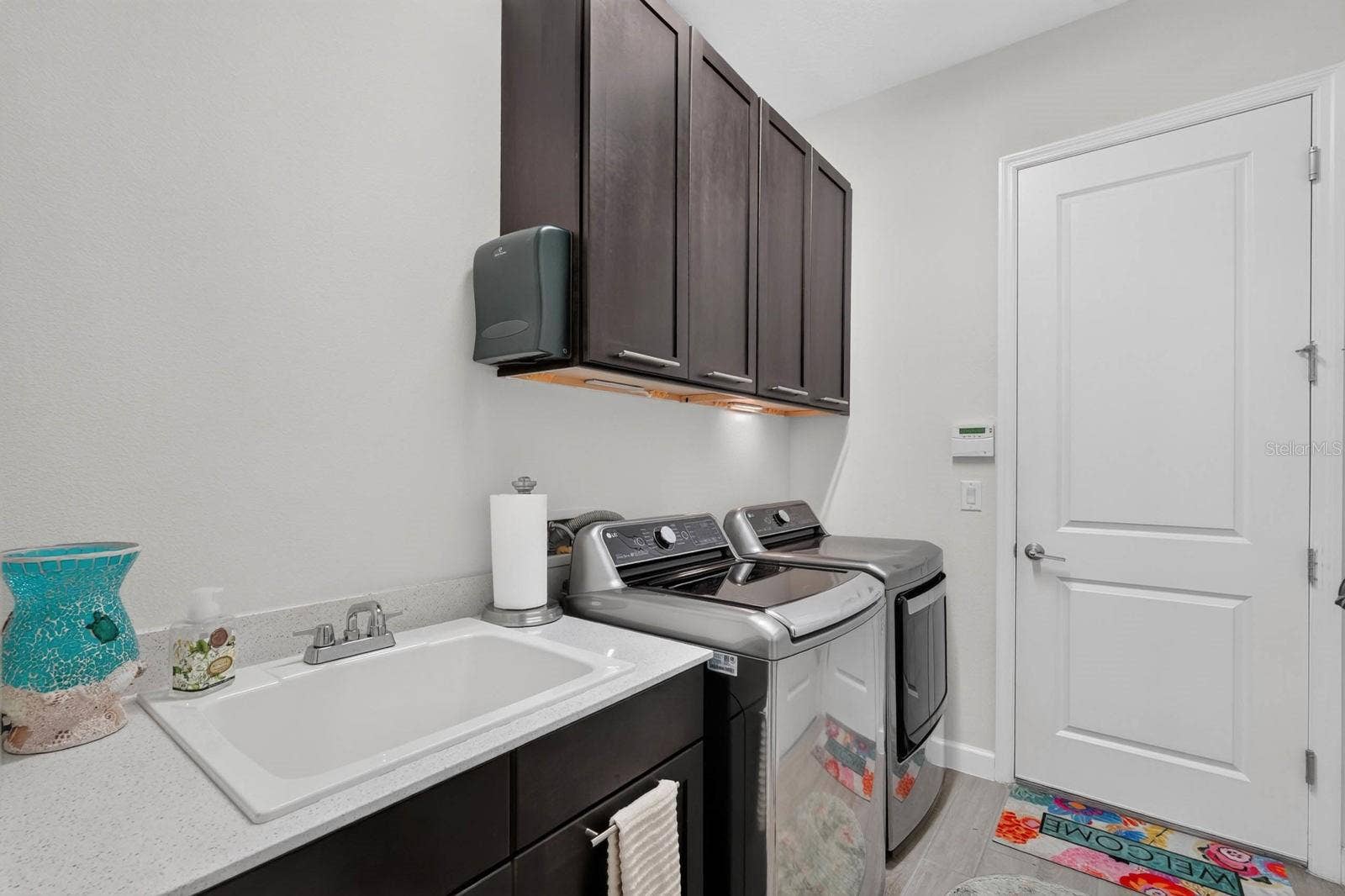 36 NEW WATER OAK DRIVE, Palm Coast, FL 32137 Laundry room has sink with cabinet plus overhead cabinetry and a storage closet