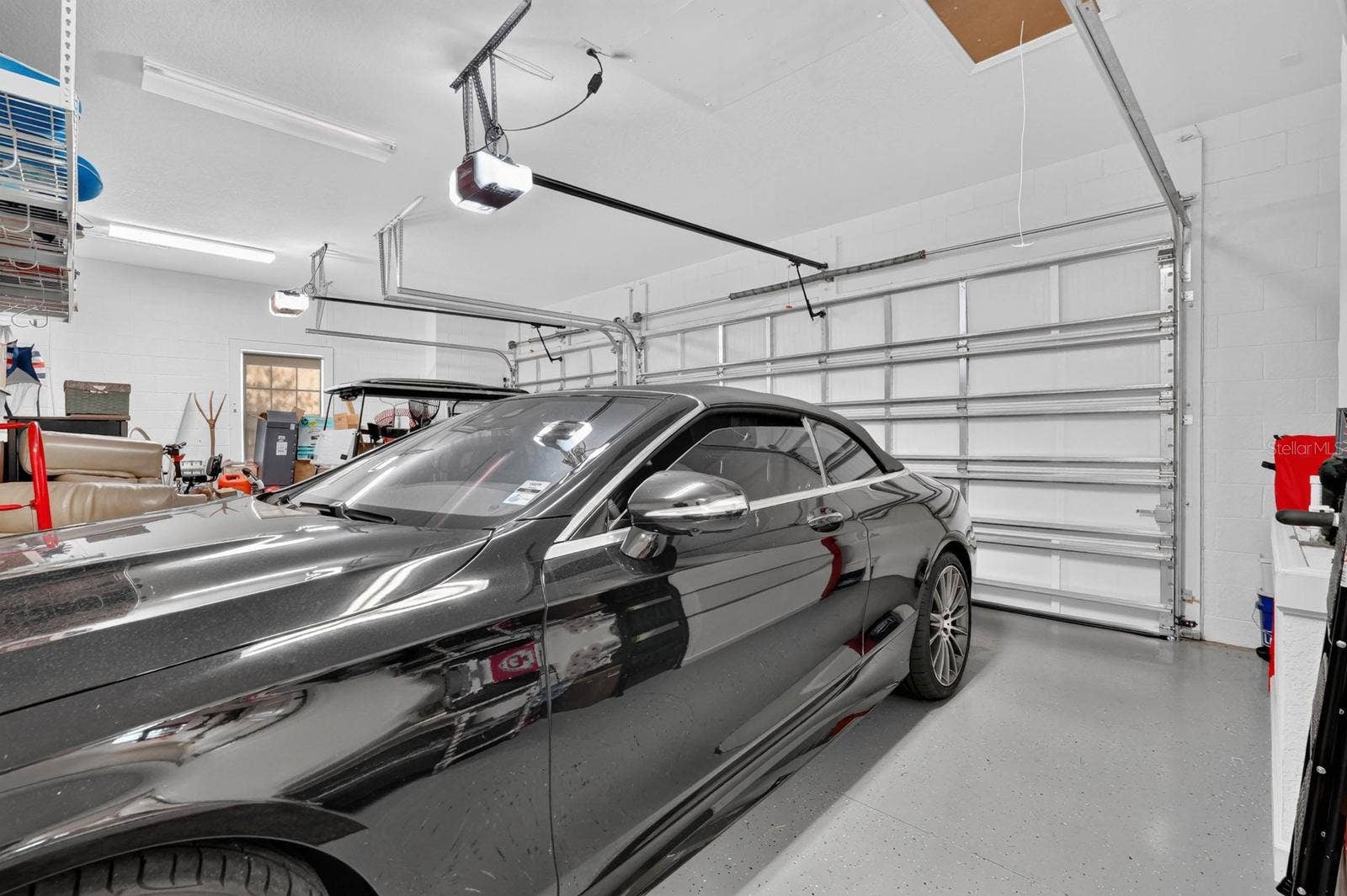36 NEW WATER OAK DRIVE, Palm Coast, FL 32137 3 car garage with coated painted floor, electronic storage lift for attic and additional storage shelving.