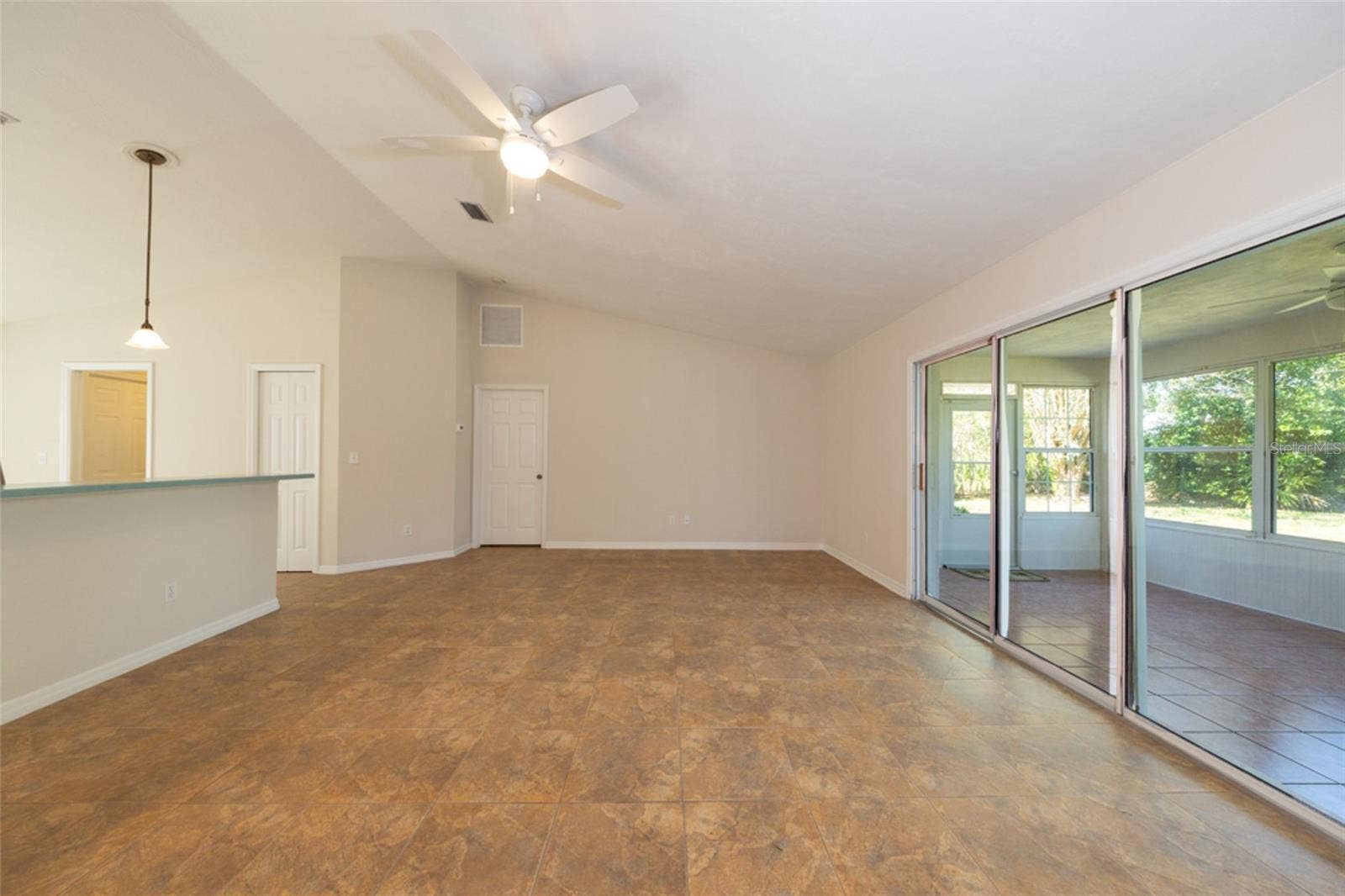 141 BREN MAR LANE, Palm Coast, FL 32137 large living room, looking towards primary bedroom. kitchen to the left, Florida room to the right.