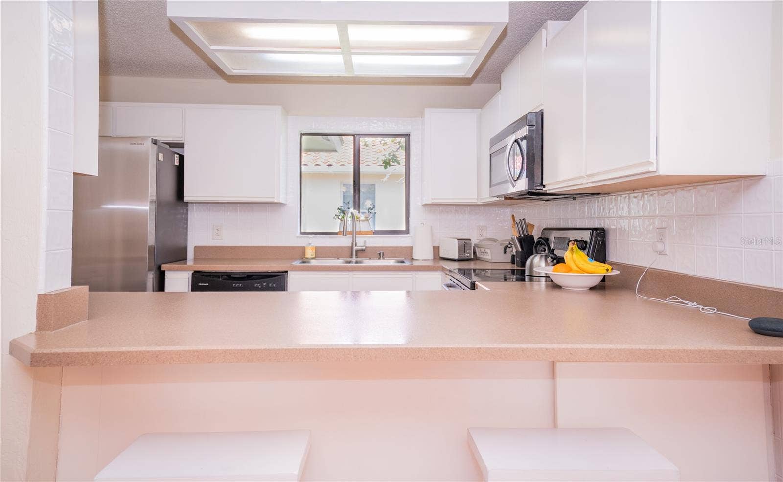 This bright and airy kitchen is the heart of the home, featuring abundant natural light and a convenient breakfast bar.