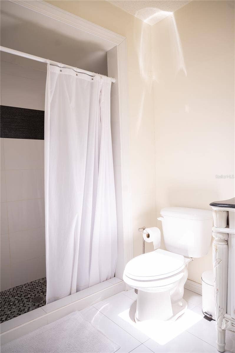 Ensuite primary bathroom featuring a spacious walk-in shower and private water closet.