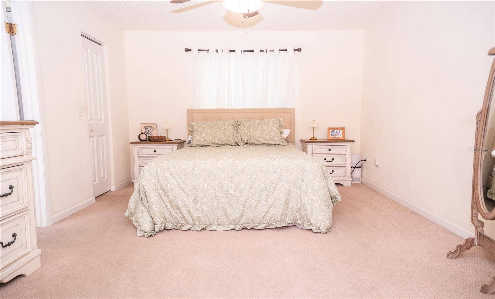 Beautiful primary bedroom featuring a spacious walk-in closet and a private ensuite bathroom off to the left.
