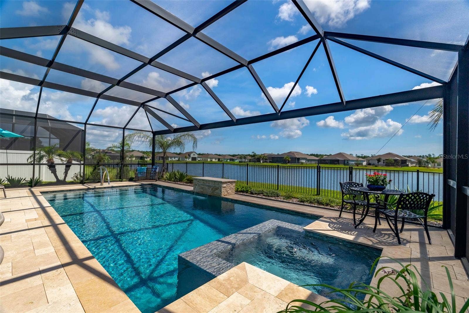 627 OCEAN JASPER DRIVE, St Augustine, FL 32086 Fully screened and heated in-ground pool with travertine deck, mosaic tiles, and waterfall.