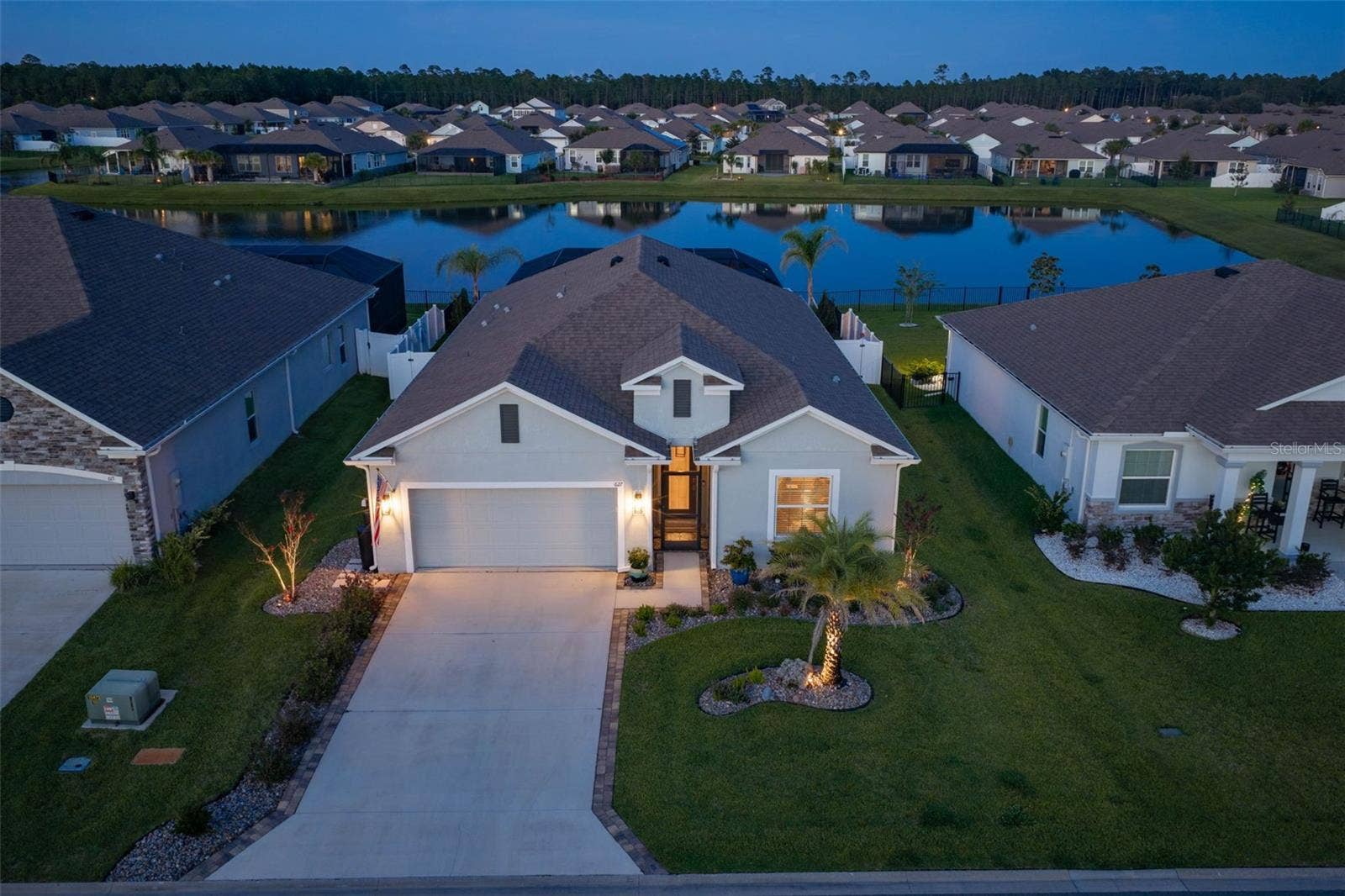 627 OCEAN JASPER DRIVE, St Augustine, FL 32086 Front view of home with landscape lighting and rear, east-facing pond view.