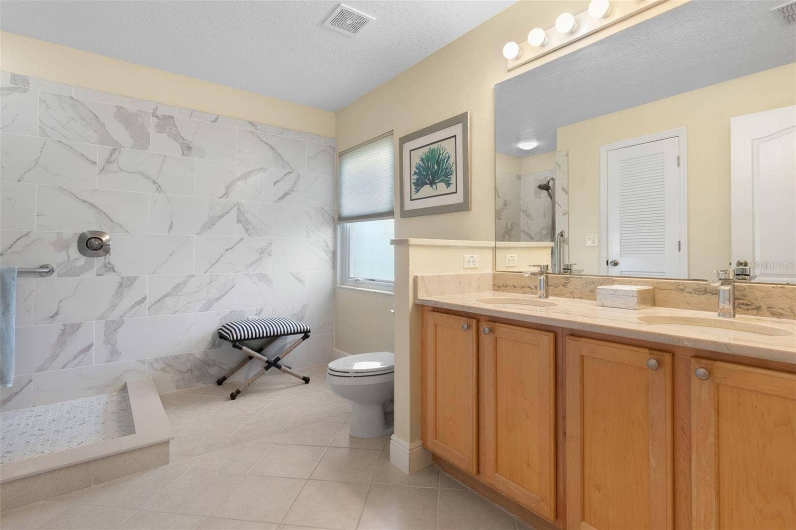 Remodeled in 2021, the primary ensuite brings a touch of spa-inspired luxury to everyday living, featuring a beautifully tiled walk-in shower, dual vanities, and elegant finishes that make getting ready a pleasure.