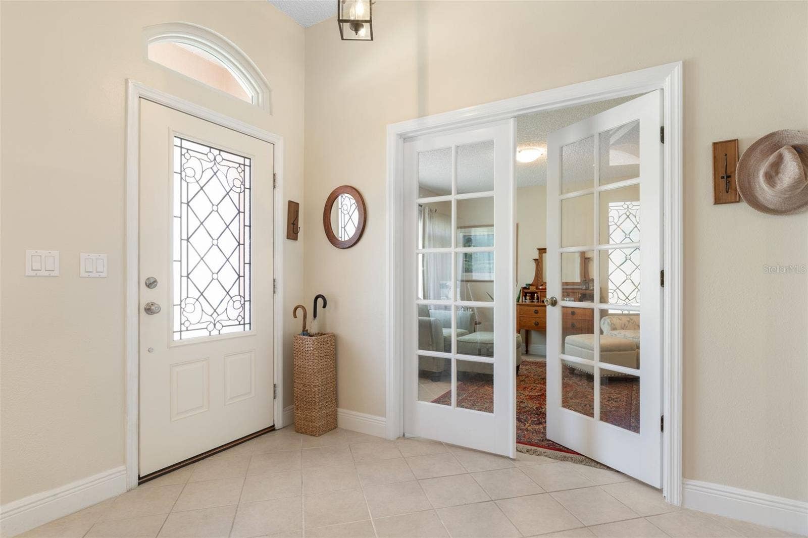 First impressions matter! This lovely foyer features a decorative glass entry door, elegant transom window, and French doors that offer a peek into the adjoining den/office, setting a gracious tone from the moment you arrive