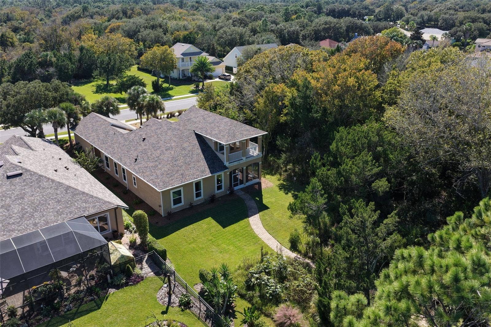 25 EMERALD LAKE COURT, Palm Coast, FL 32137 A spacious backyard surrounded by natural greenery, offering privacy and a peaceful setting to enjoy the outdoors.