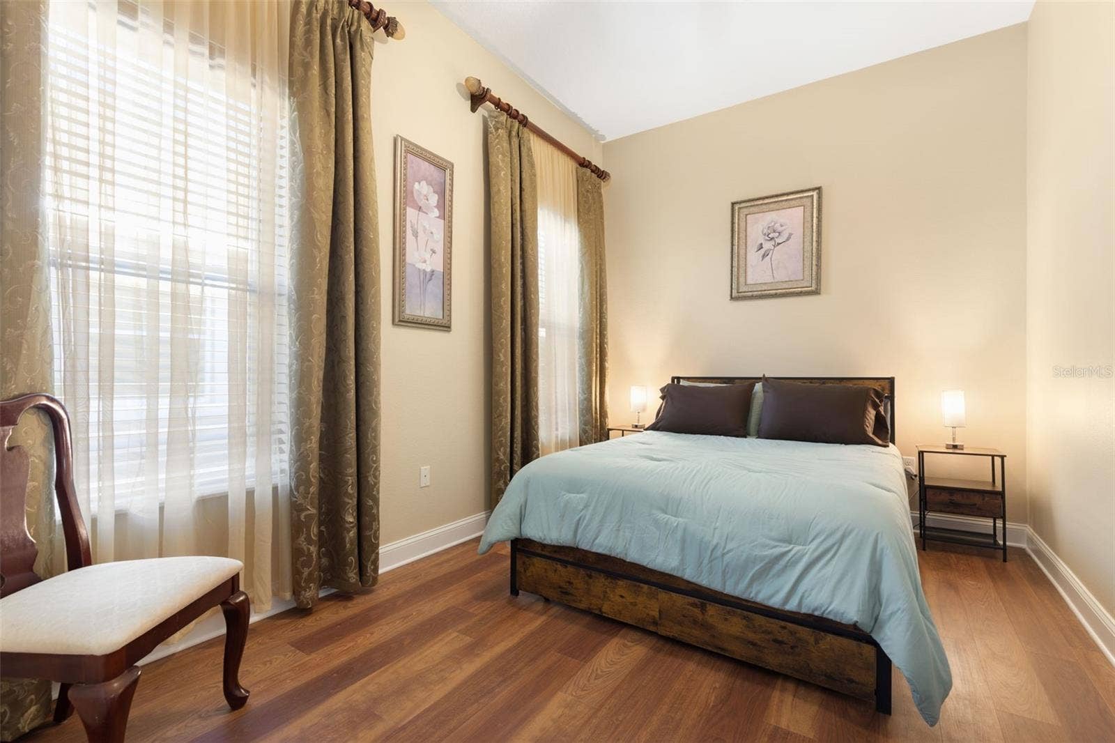 25 EMERALD LAKE COURT, Palm Coast, FL 32137 First-Floor Bedroom #2 offers a tranquil, comfortable retreat with warm wood-look flooring and a peaceful atmosphere.