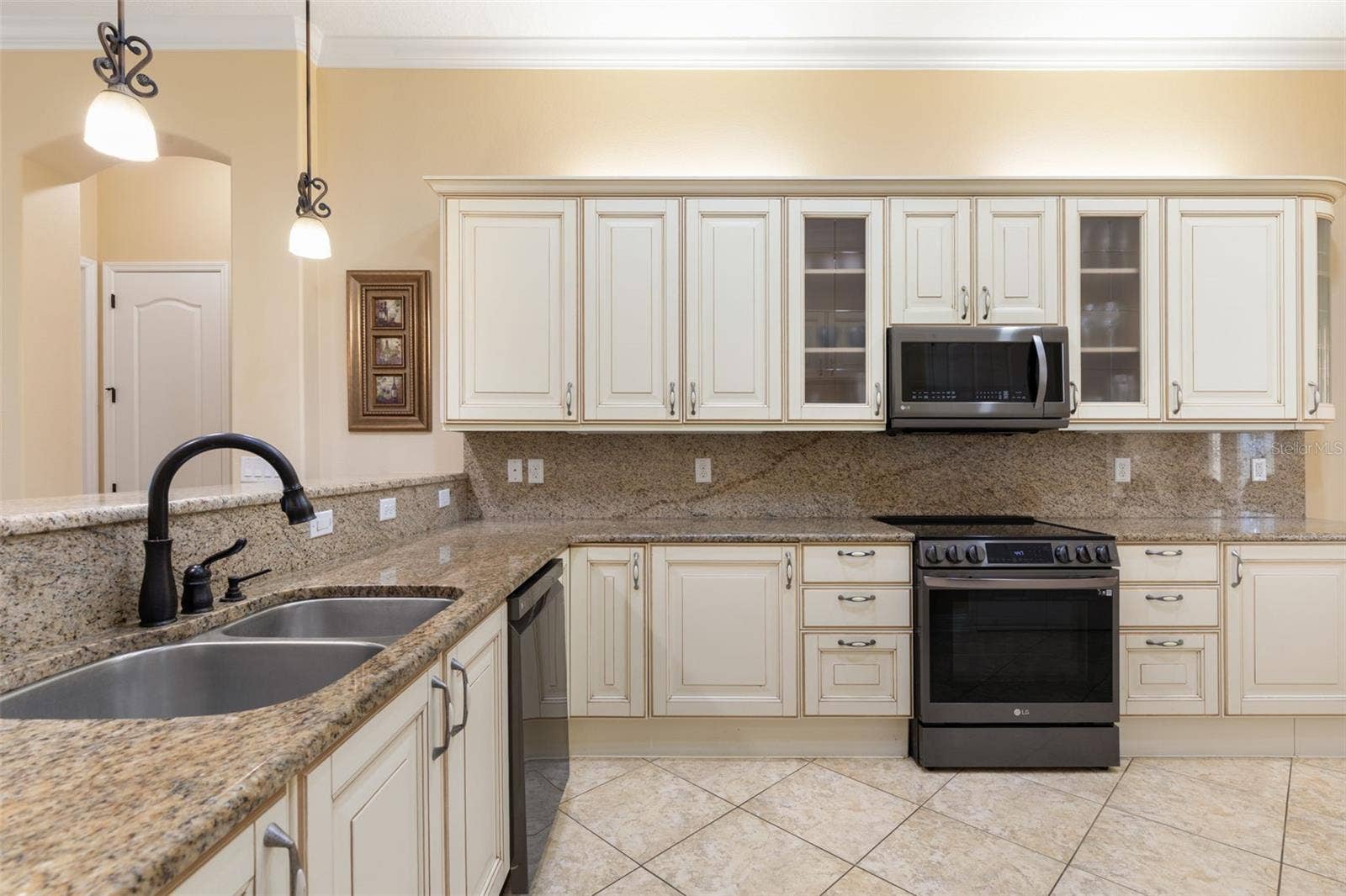 25 EMERALD LAKE COURT, Palm Coast, FL 32137 Italian-inspired cabinetry, granite countertops and matching backsplash bring timeless elegance to this beautifully designed kitchen.