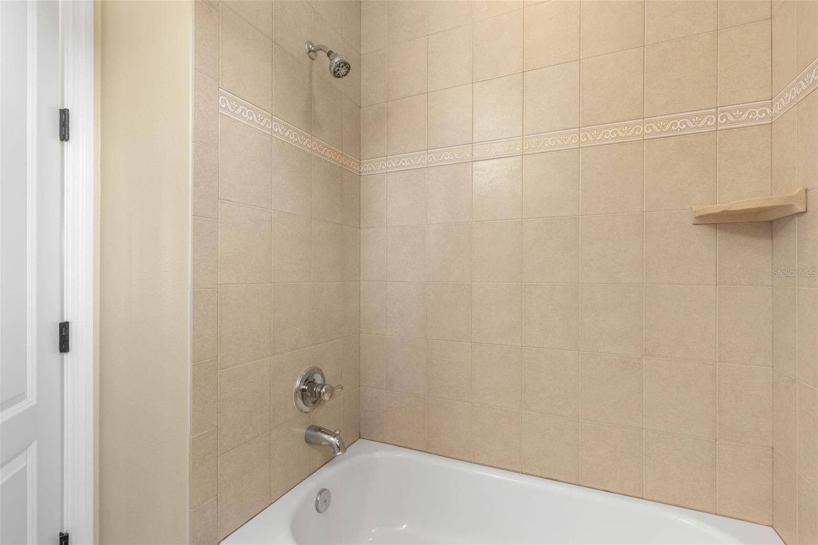 25 EMERALD LAKE COURT, Palm Coast, FL 32137 Decorative tile accents and a built-in corner shelf add thoughtful details to the upstairs bathroom's tub/shower combination.