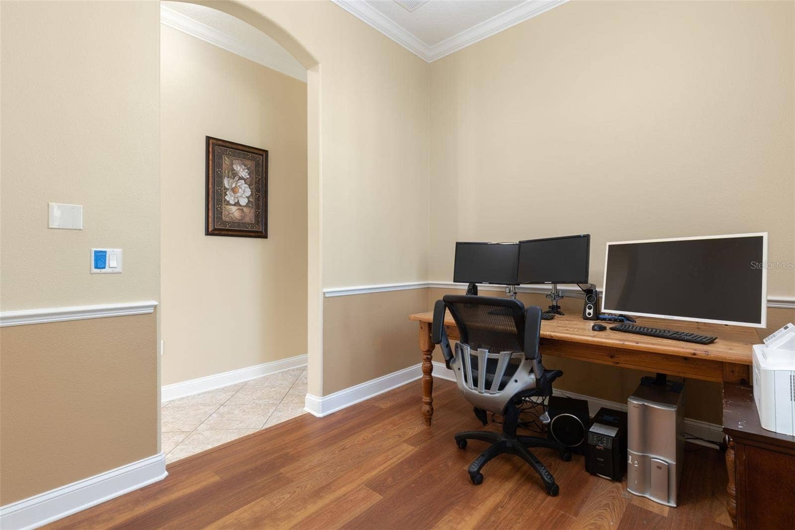 25 EMERALD LAKE COURT, Palm Coast, FL 32137 Another perspective of the office/den, highlighting the graceful arched entryway, crown molding, and chair rail detailing.