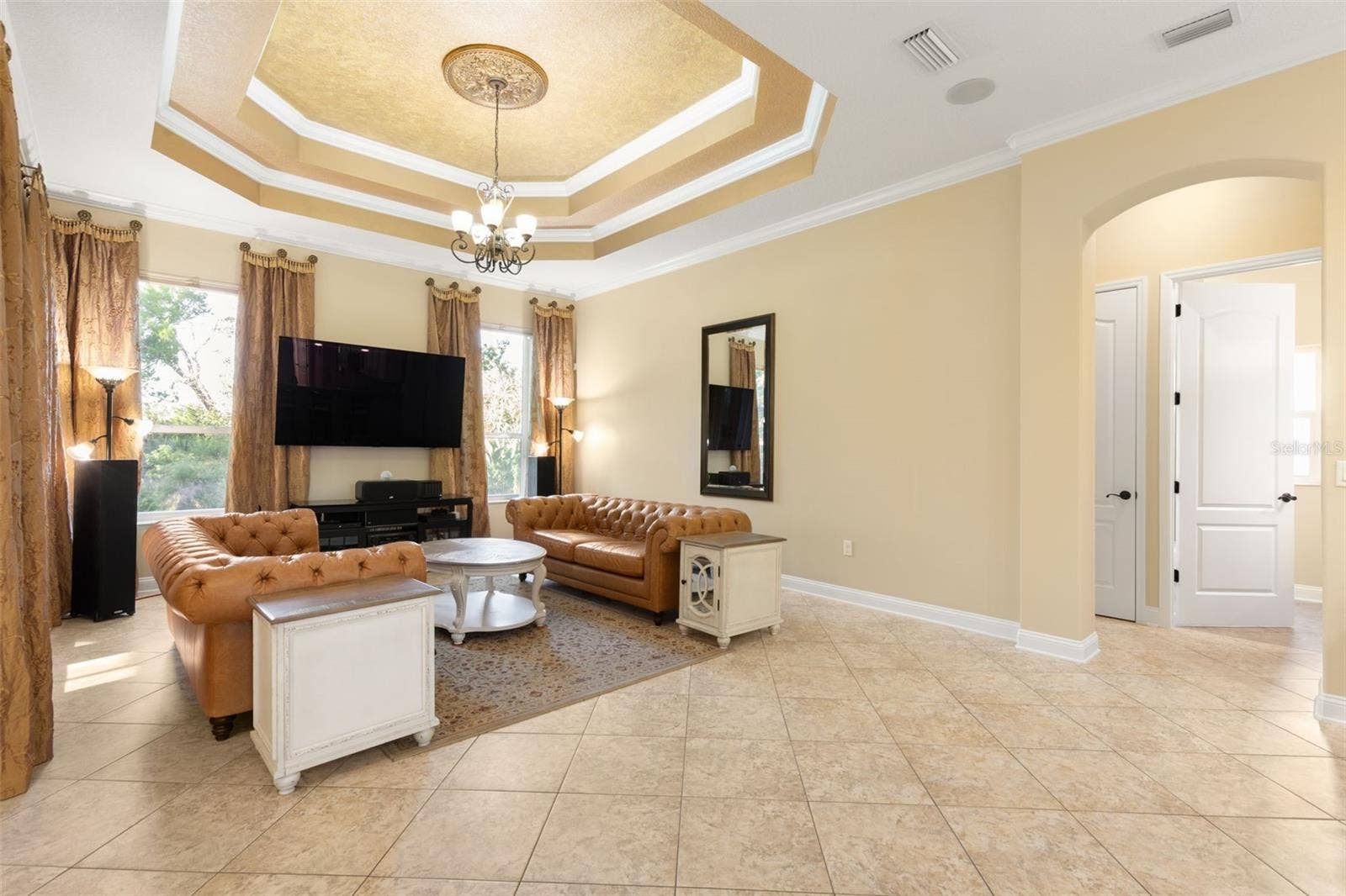 25 EMERALD LAKE COURT, Palm Coast, FL 32137 An elegant gathering room where a dramatic tray ceiling, crown molding and decorative lighting create a beautiful setting for relaxing and entertaining.