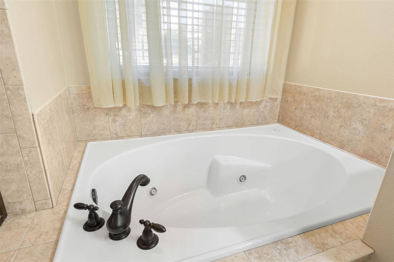 25 EMERALD LAKE COURT, Palm Coast, FL 32137 Unwind in the generously sized soaking tub, positioned beneath a window that brings soft natural light into the space.