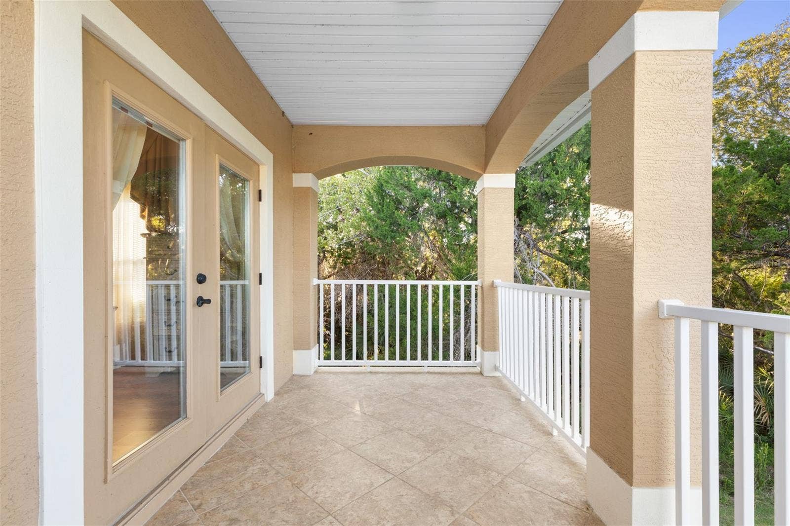 25 EMERALD LAKE COURT, Palm Coast, FL 32137 Another perspective of the covered balcony highlights its generous space, tiled flooring and direct access from the upstairs suite.