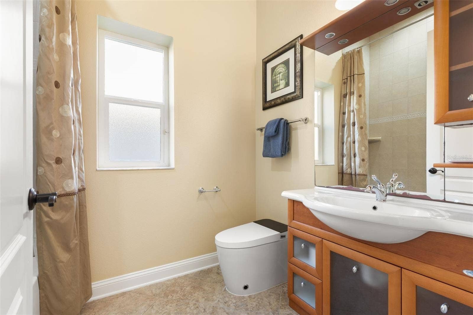 25 EMERALD LAKE COURT, Palm Coast, FL 32137 Italian-inspired first-floor guest bathroom featuring distinctive wood cabinetry, decorative tile flooring, and a tub/shower combination.