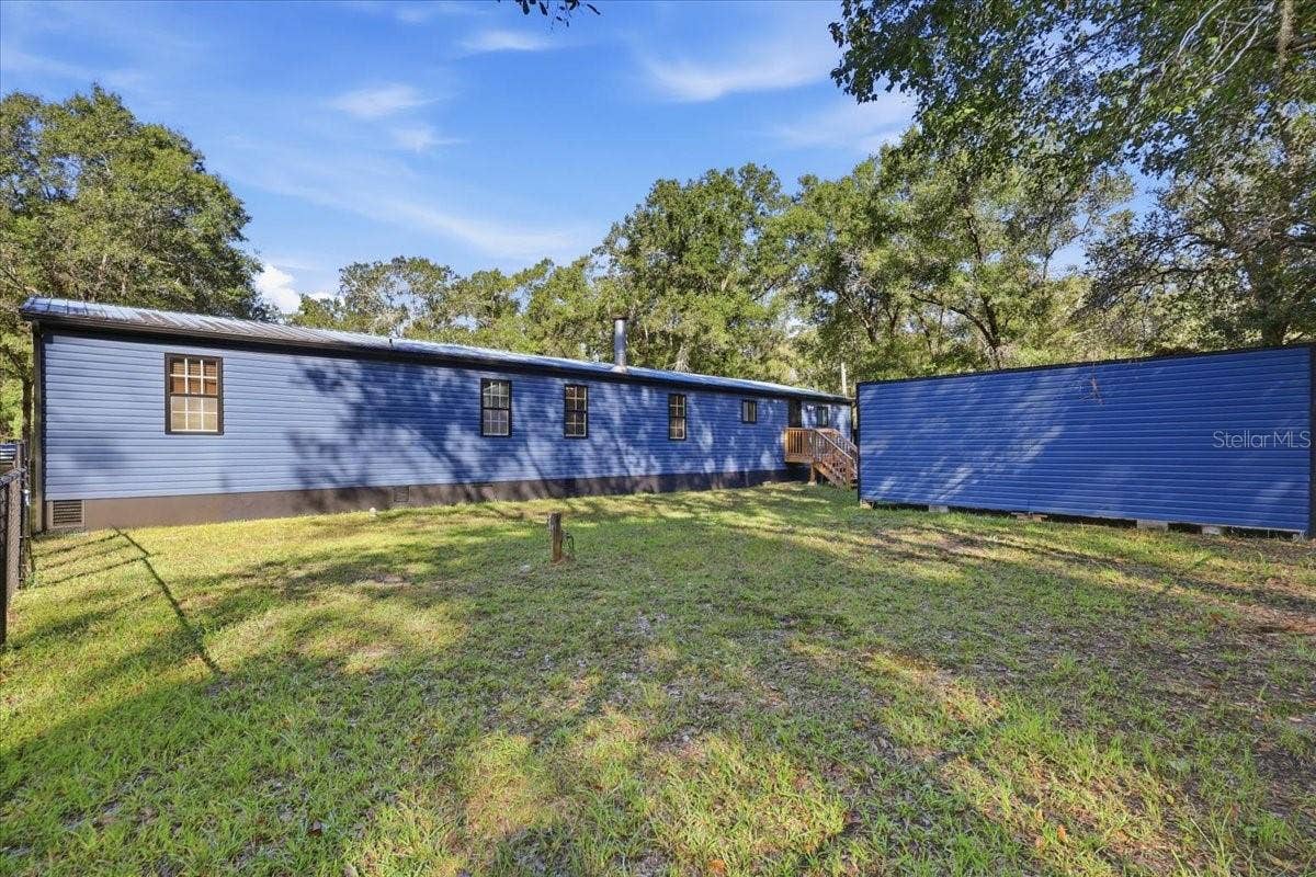 9860 NIKOLICH AVENUE, Hastings, FL 32145 Back of home showing back stairs and Shed.