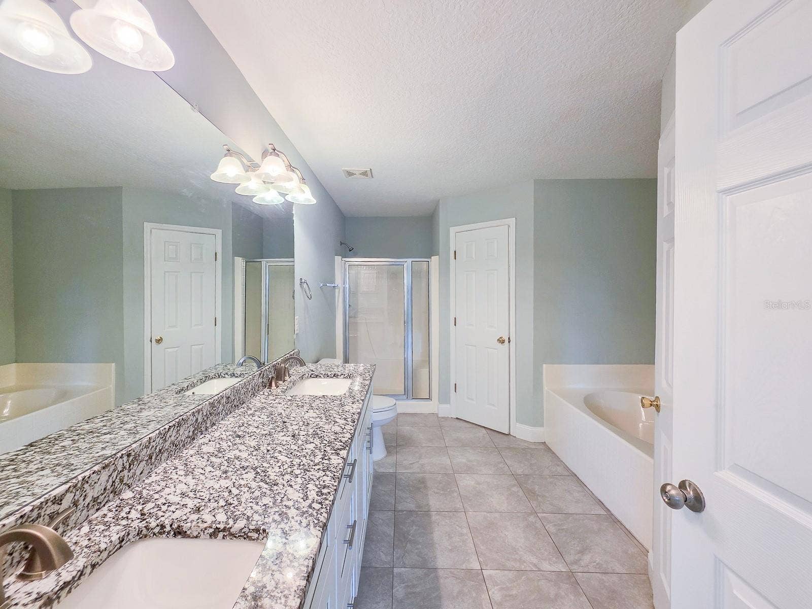 4 LLOWICK COURT, Palm Coast, FL 32164 Primary bath with soaking tub, shower, double sinks, granite tops and his and hers closets