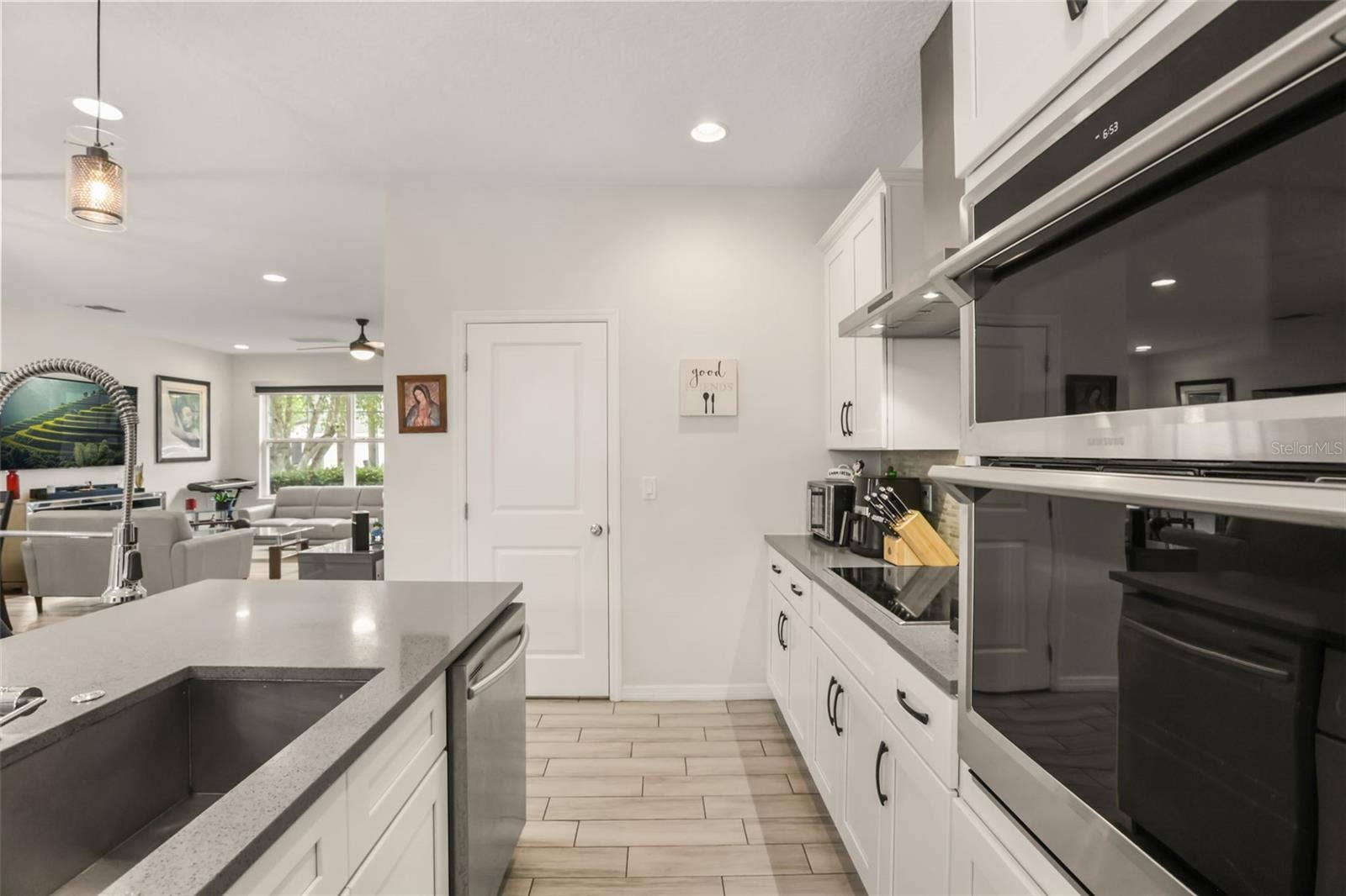 Well-appointed kitchen featuring built-in oven and microwave, solid surface countertops, abundant cabinetry, and a functional layout for everyday living.