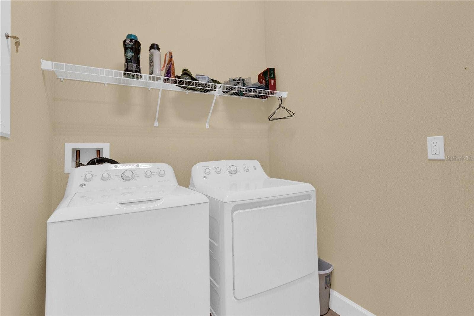 Convenient upstairs laundry room with built-in shelving.