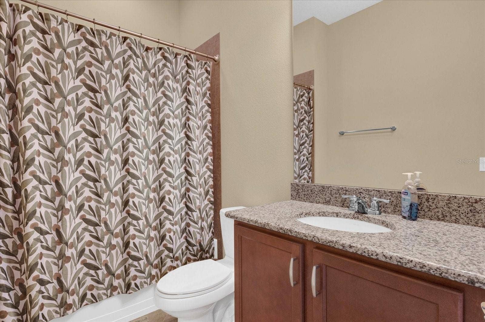 Full guest bathroom with tub/shower combo and vanity storage.