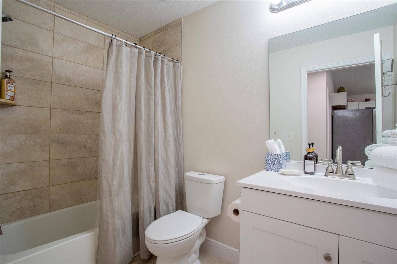 Second Bathroom with a single vanity, tub with shower