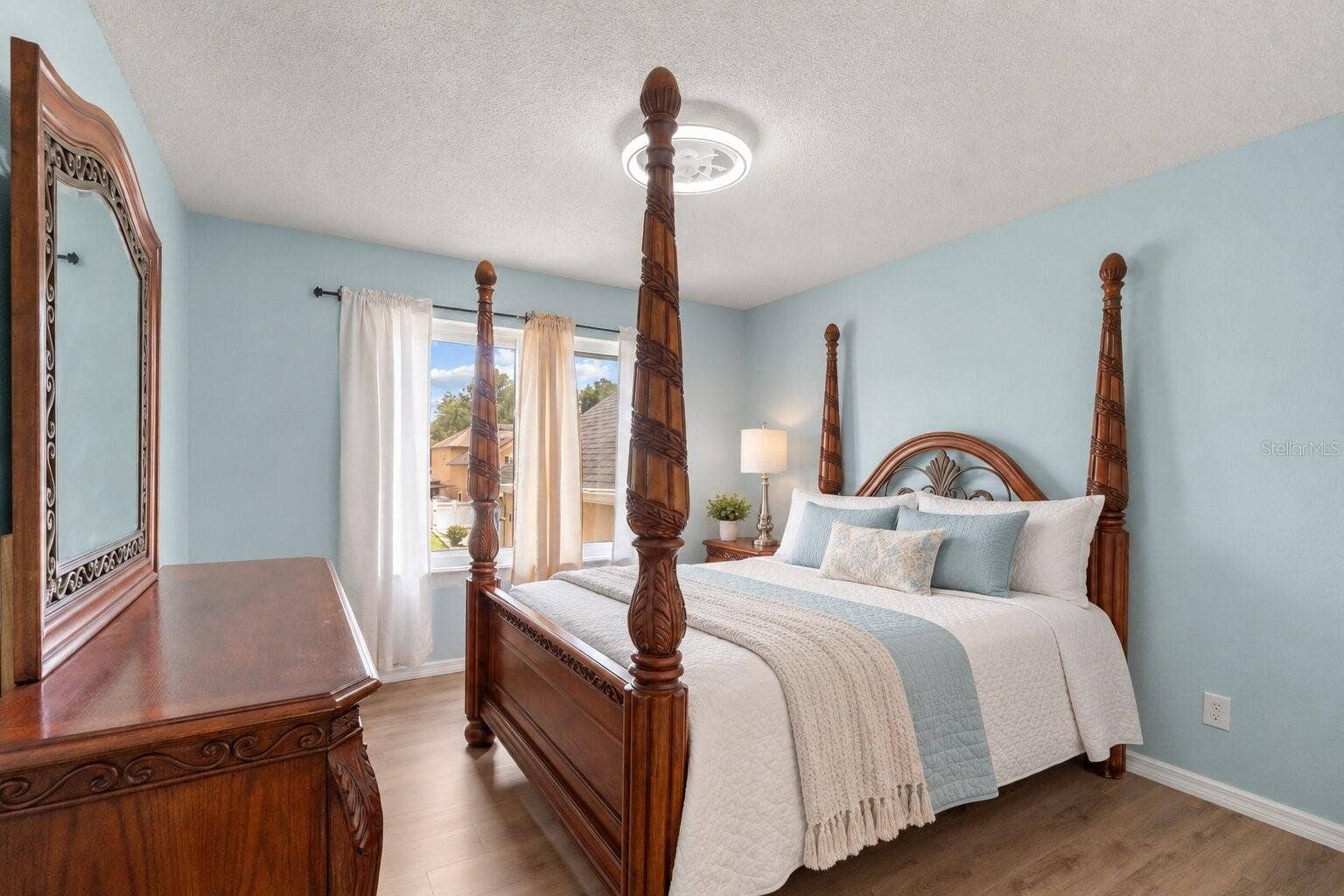 211 HUNT STREET, Clermont, FL 34711 Spacious bedroom with natural light and wood look flooring.