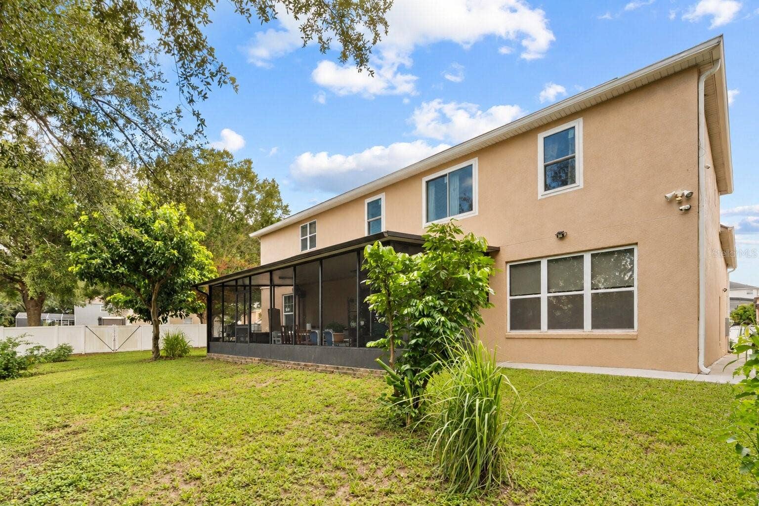 211 HUNT STREET, Clermont, FL 34711 Rear exterior view highlighting the large backyard and screened patio.