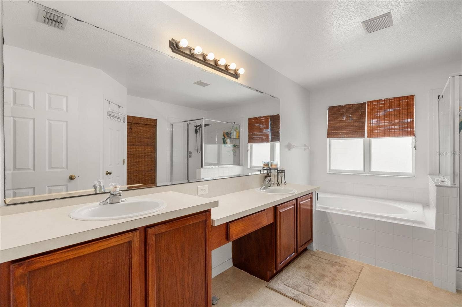 211 HUNT STREET, Clermont, FL 34711 Primary bathroom with dual-sink vanity, large mirror, and generous counter space.