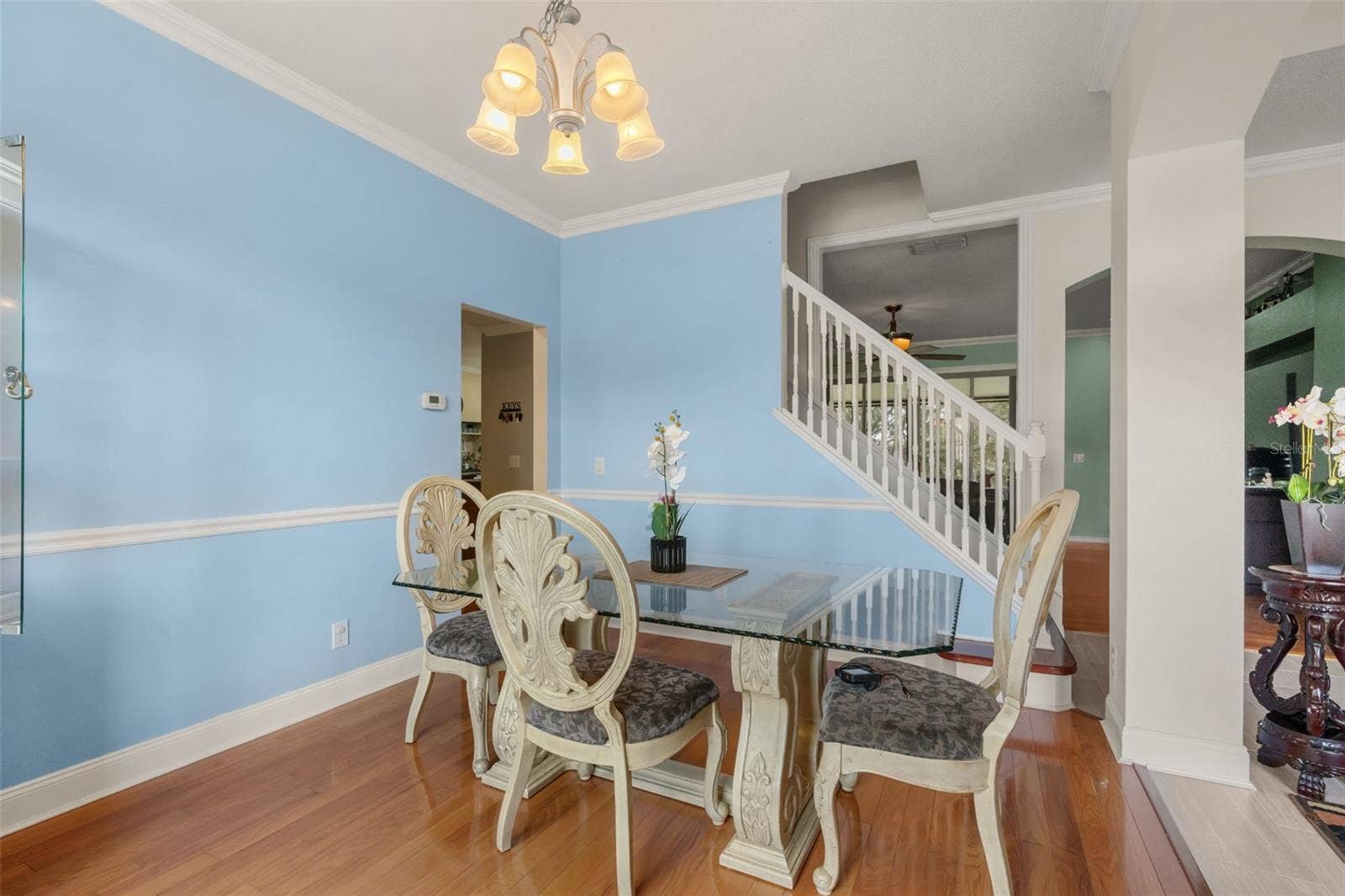 211 HUNT STREET, Clermont, FL 34711 Bright dining area with large windows, chandelier, and plenty of natural light.