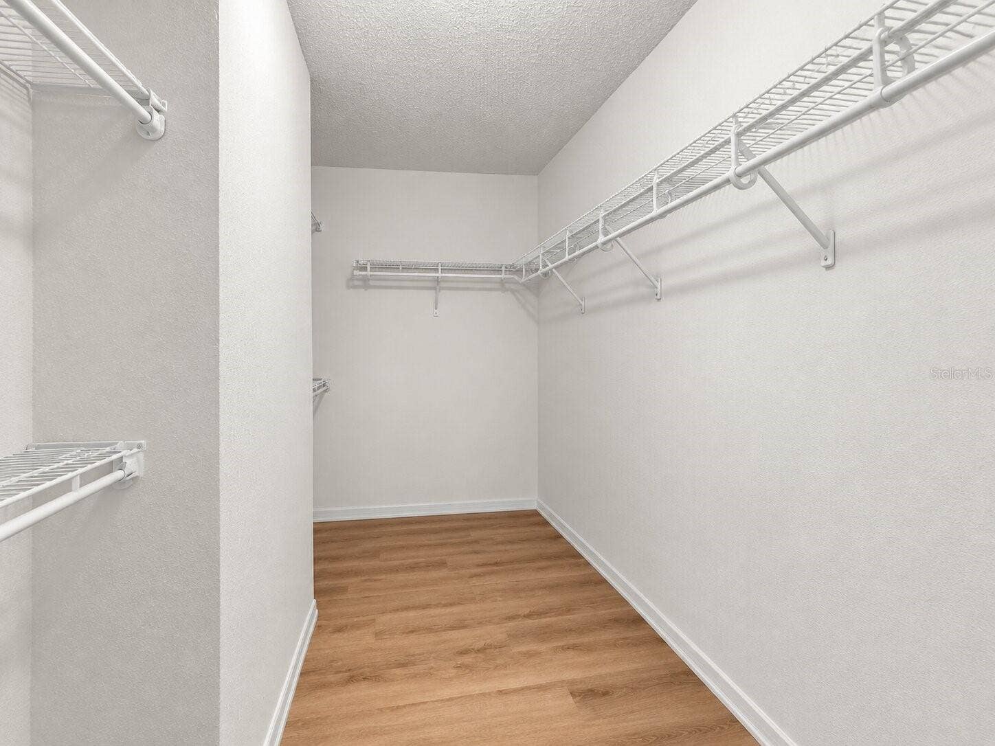 211 HUNT STREET, Clermont, FL 34711 Primary bedroom walk-in closet with built-in shelving and ample storage space.