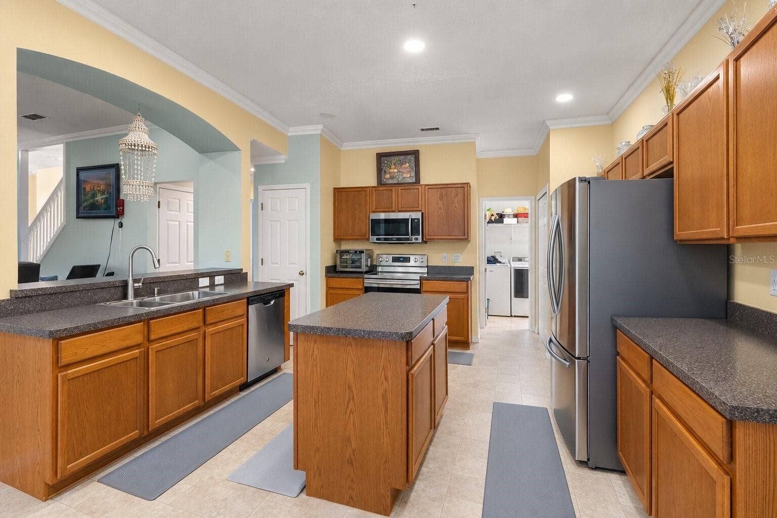 211 HUNT STREET, Clermont, FL 34711 Additional kitchen view highlighting the cabinetry, appliances, and ample workspace.