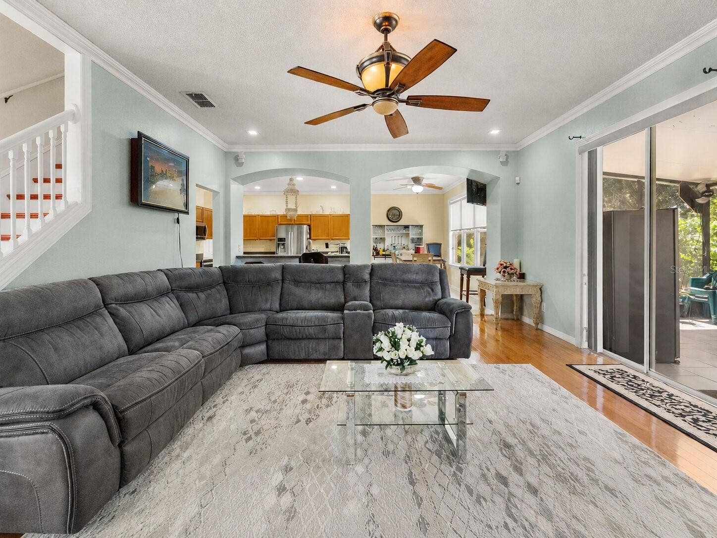 211 HUNT STREET, Clermont, FL 34711 Large family room featuring sectional seating, ceiling fan, and abundant natural light