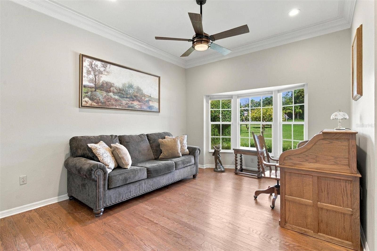 8732 SPRING COURT, Leesburg, FL 34788 Formal Living Area features wood flooring, bay windows, and overlooks Family Room.