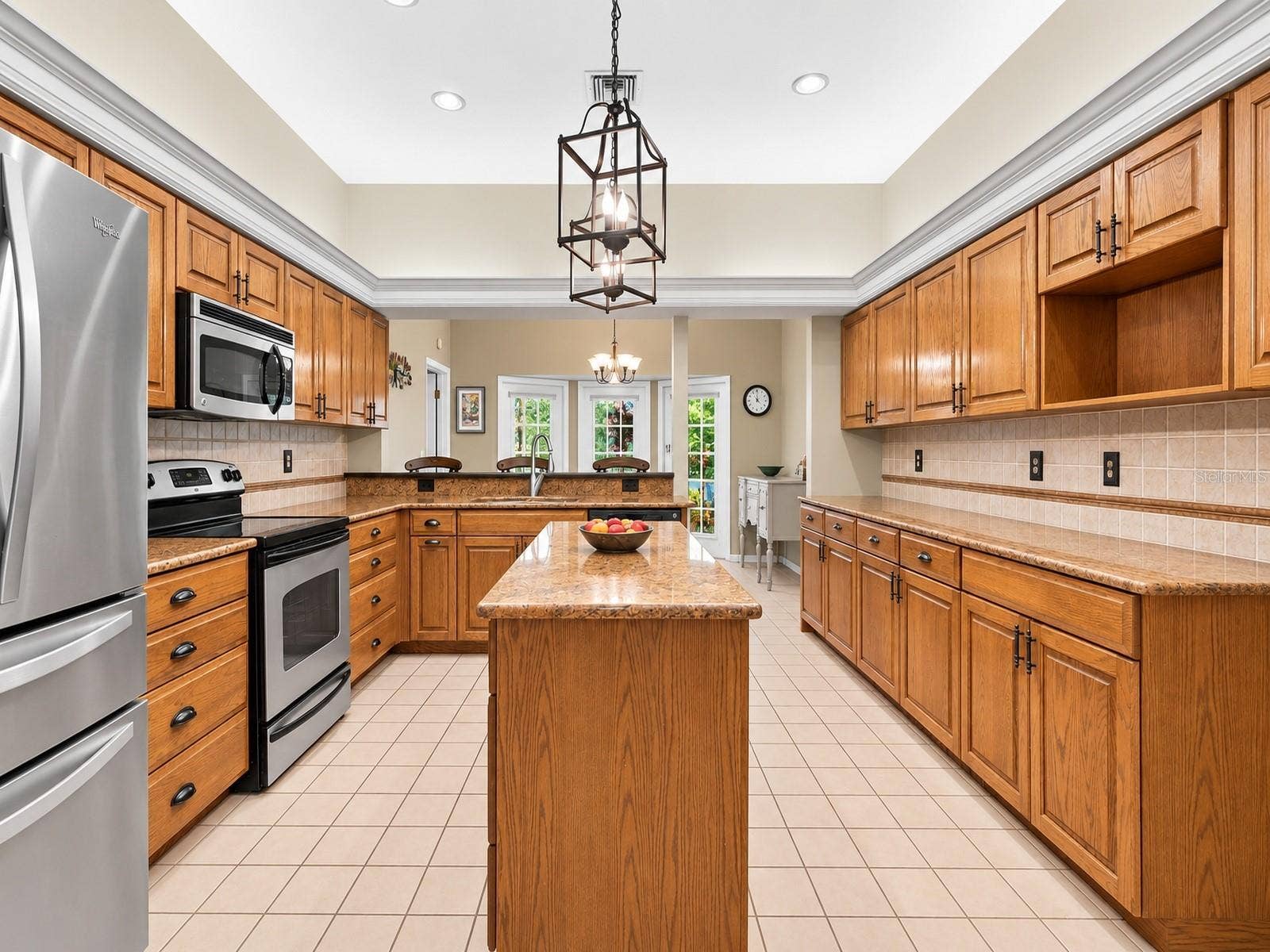 8732 SPRING COURT, Leesburg, FL 34788 Kitchen features oak cabinetry, center island, granite countertops, and stainless steel appliances.