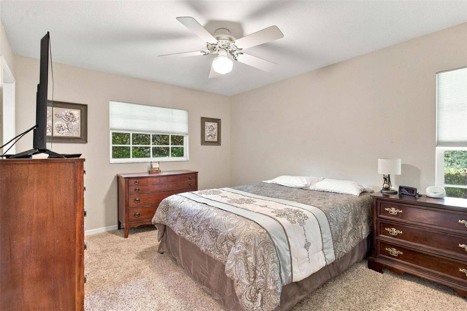 8732 SPRING COURT, Leesburg, FL 34788 Split Floor Plan-Bedroom #3 features carpet, door leading to lanai and door leading to private entry into bathroom.