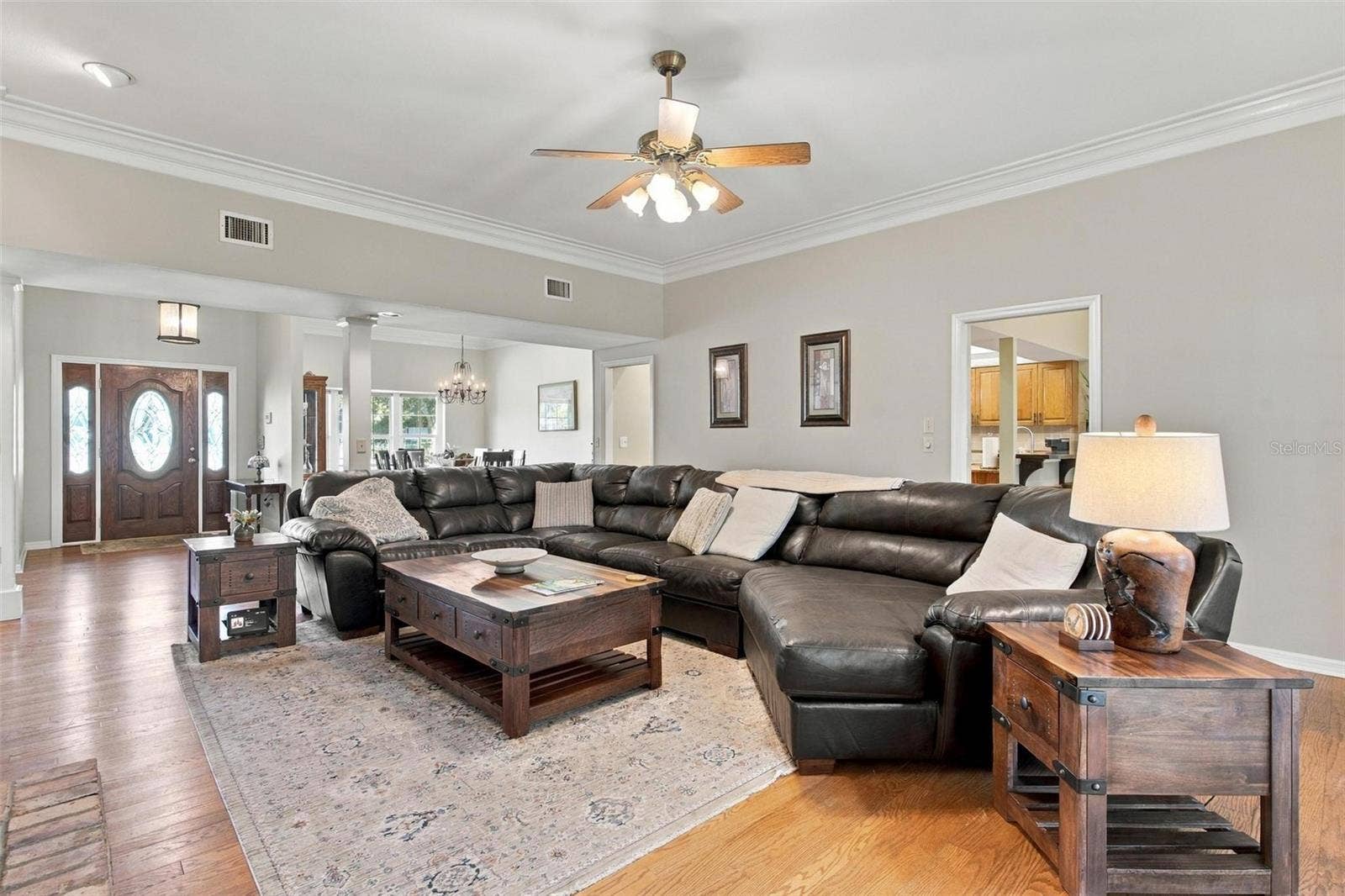 8732 SPRING COURT, Leesburg, FL 34788 Family Room features wood flooring, wood burning fireplace, built in shelving, and French door leading to screened enclosed lanai